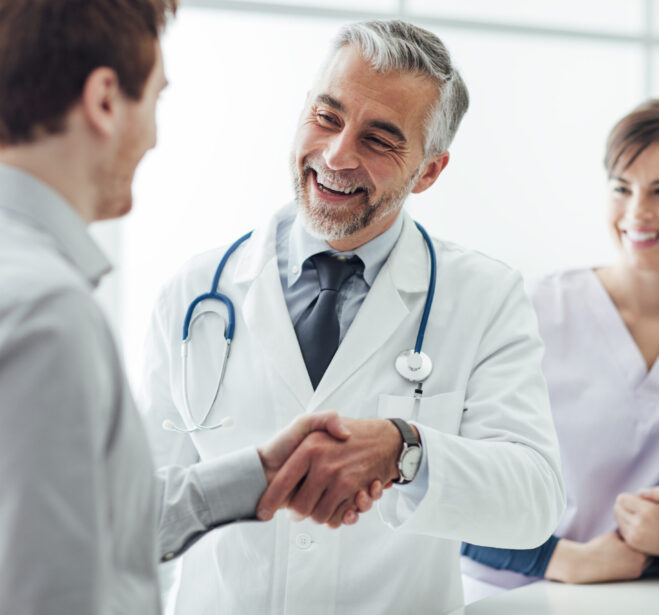 Smiling doctor at the clinic giving an handshake to his patient, healthcare and professionalism concept